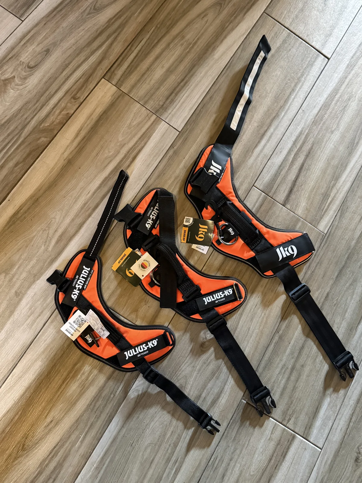 Three genuine Julius-K9 IDC Powerharnesses fanned out with certified hangtags and authorized-source packaging attached